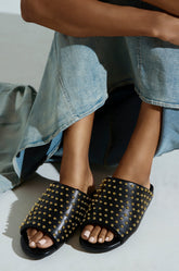 AKIRA BAGGER STUDDED SLIP ON SANDAL IN BLACK